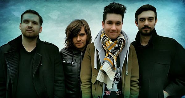 Youthful band members posing outdoors with a dynamic sky background, showcasing musical group promotion and concert imagery.