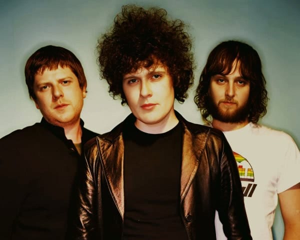 Retro music band photo with three indie rock musicians, historical music archive, and cultural artists representing past daily news and music history.