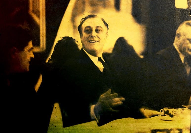 Vintage black and white photo of men in formal attire enjoying a social gathering, emphasizing historical news, music, and cultural archives from Past Daily sound archive.