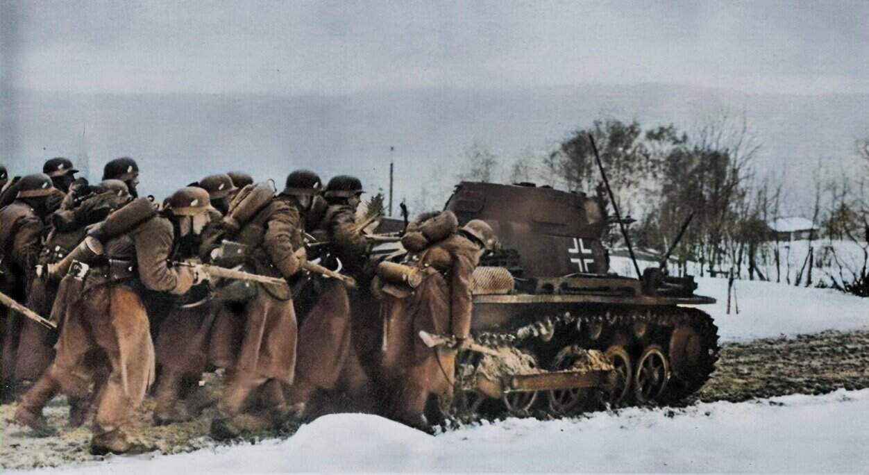 German soldiers advancing with a tank during winter WWII, emphasizing historical military conflict.