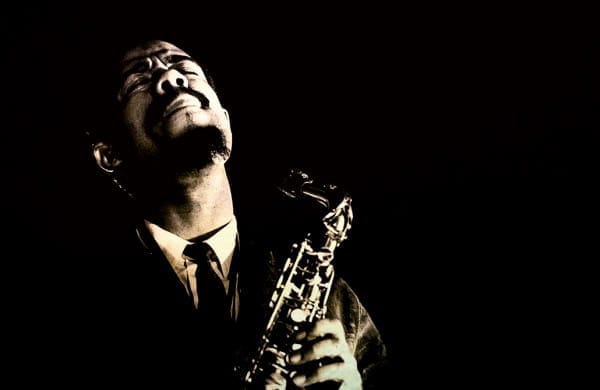 Saxophonist passionately playing jazz music, black and white image emphasizing emotion and musical expression.