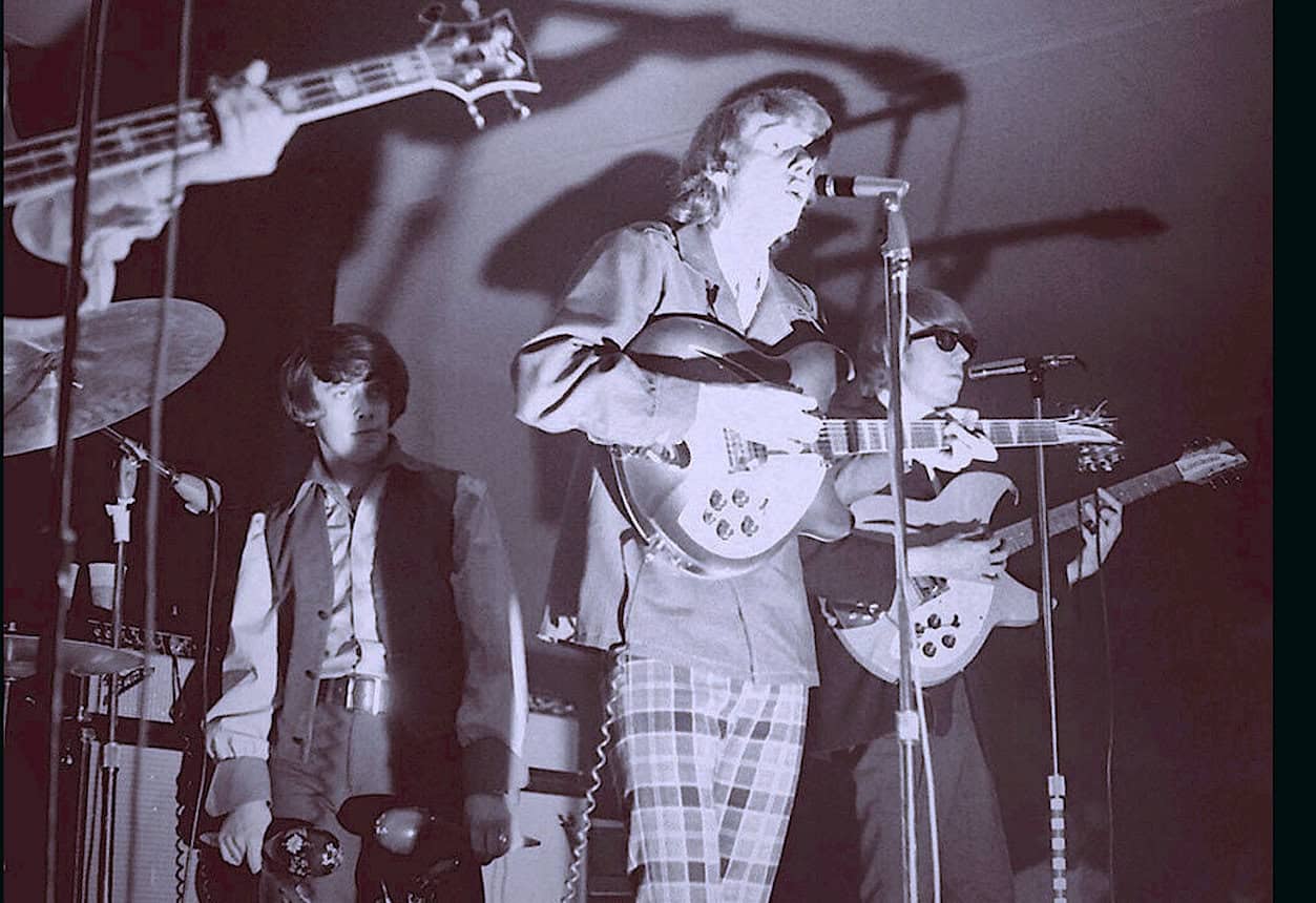 Vintage band performance with acoustic guitars on stage, capturing a nostalgic music scene from past concerts, reflecting historical sound archives and iconic musical moments.