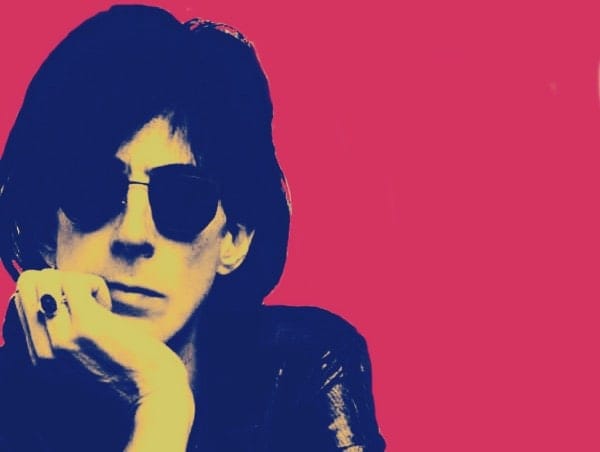 A black and white stylized photo of a woman with sunglasses set against a pink background, evoking classic music and news archive themes.