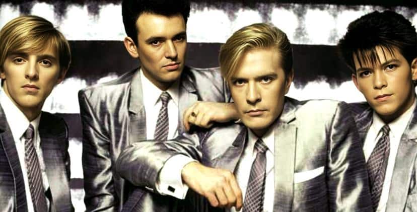 Vintage band members wearing suits for a retro music photo shoot, emphasizing classic music and entertainment themes.