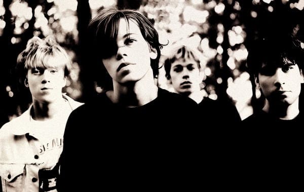 A black and white image of a band with four members, highlighting vintage music photography and historical sound archives.