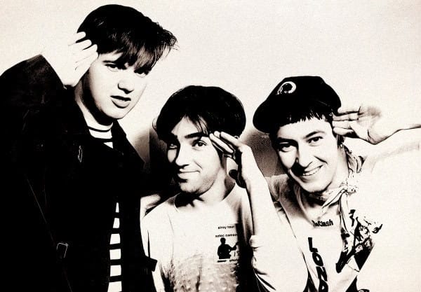 Nostalgic 1980s punk rock band members saluting, black and white music history photograph for past daily sound archive SEO.