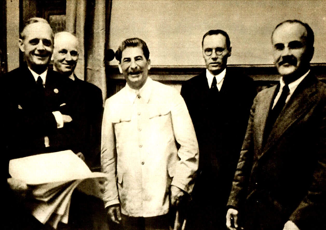Historical black and white photo of five men in formal attire standing together indoors, vintage photo capturing a moment in history, likely from the mid-20th century, connected to news, music, and history archives on pastdaily.com.