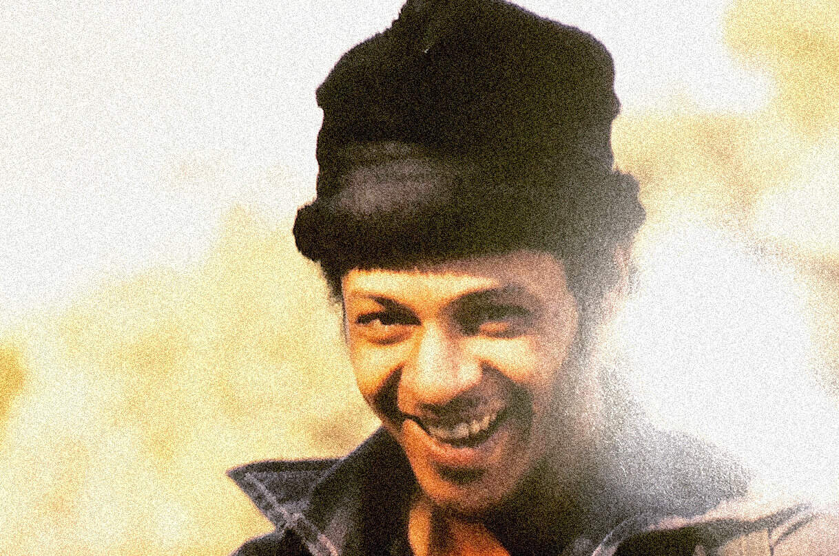 Vintage black and white photo of a smiling young man with a retro hairstyle, representing historical news, music, and cultural archives from Past Daily.