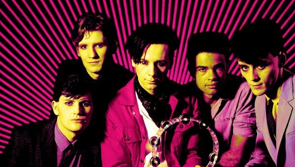 Vintage photo of The Bangles band members, showcasing 80s pop rock style with colorful outfits and vibrant background, emphasizing music history and iconic band moments.