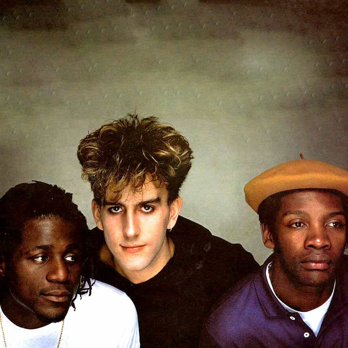 Vintage music group with diverse members, featuring iconic hairstyles and fashionable clothing, representing a classic era of music history highlighted in the Past Daily sound archive.