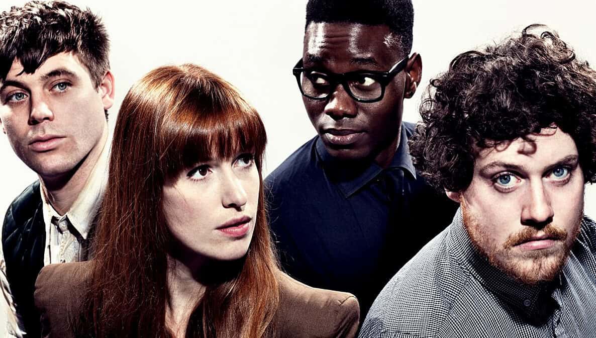 People in a band photo with diverse hair and skin tones, expressive faces, music enthusiasts, artistic performers, stylish clothing, vibrant atmosphere, concert or recording studio setting.