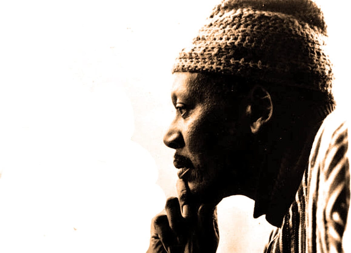 Thoughtful African American man wearing a knit cap, deep in reflection about news, history, or music archives, illustrating the importance of preserving cultural and historical sound recordings.