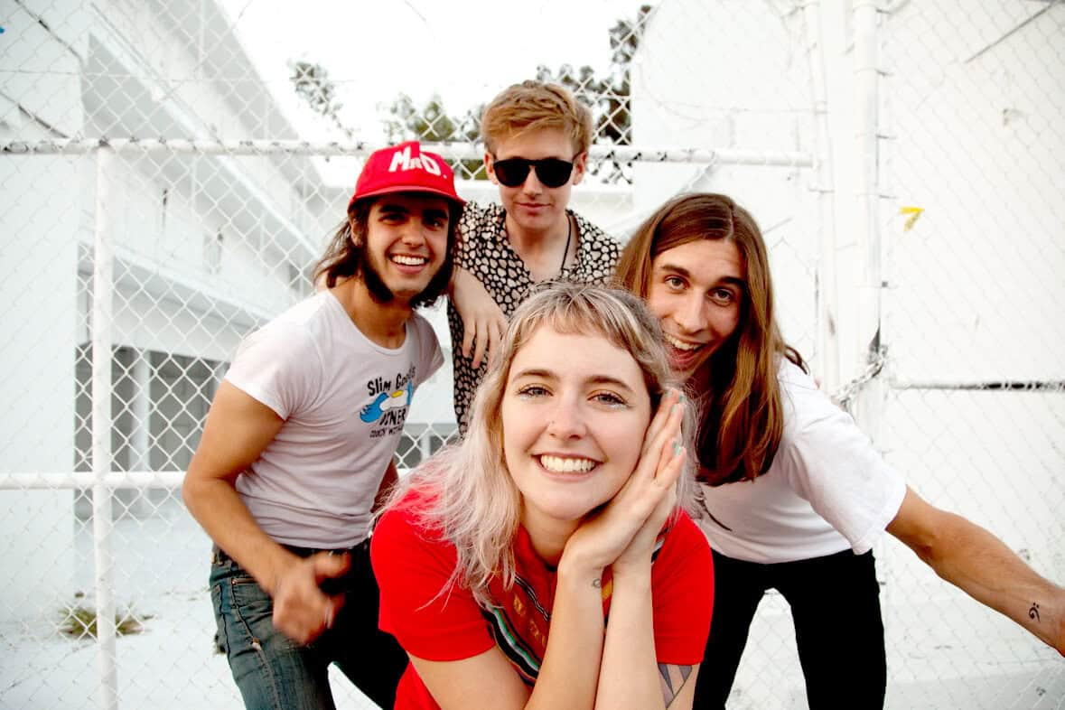 People enjoying outdoor music festival with vibrant atmosphere and diverse crowd in casual clothing and sunglasses.