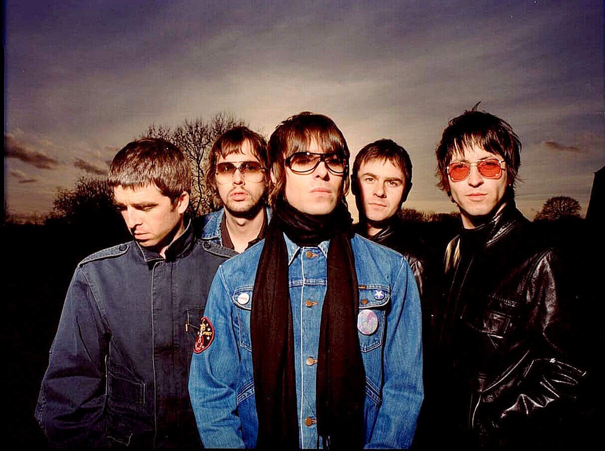 - Vintage image of a popular 2000s indie rock band wearing leather jackets and sunglasses during outdoor sunset, capturing music history and cultural moments.