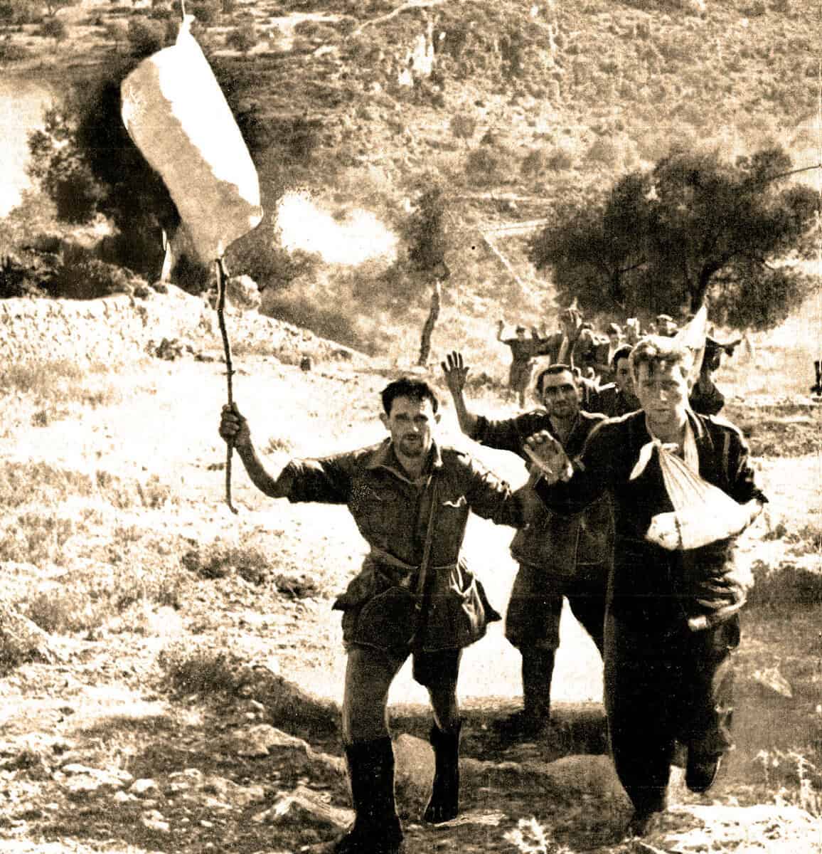 Historical photo of Israeli soldiers celebrating victory during the Six-Day War with flags, in a desert landscape.
