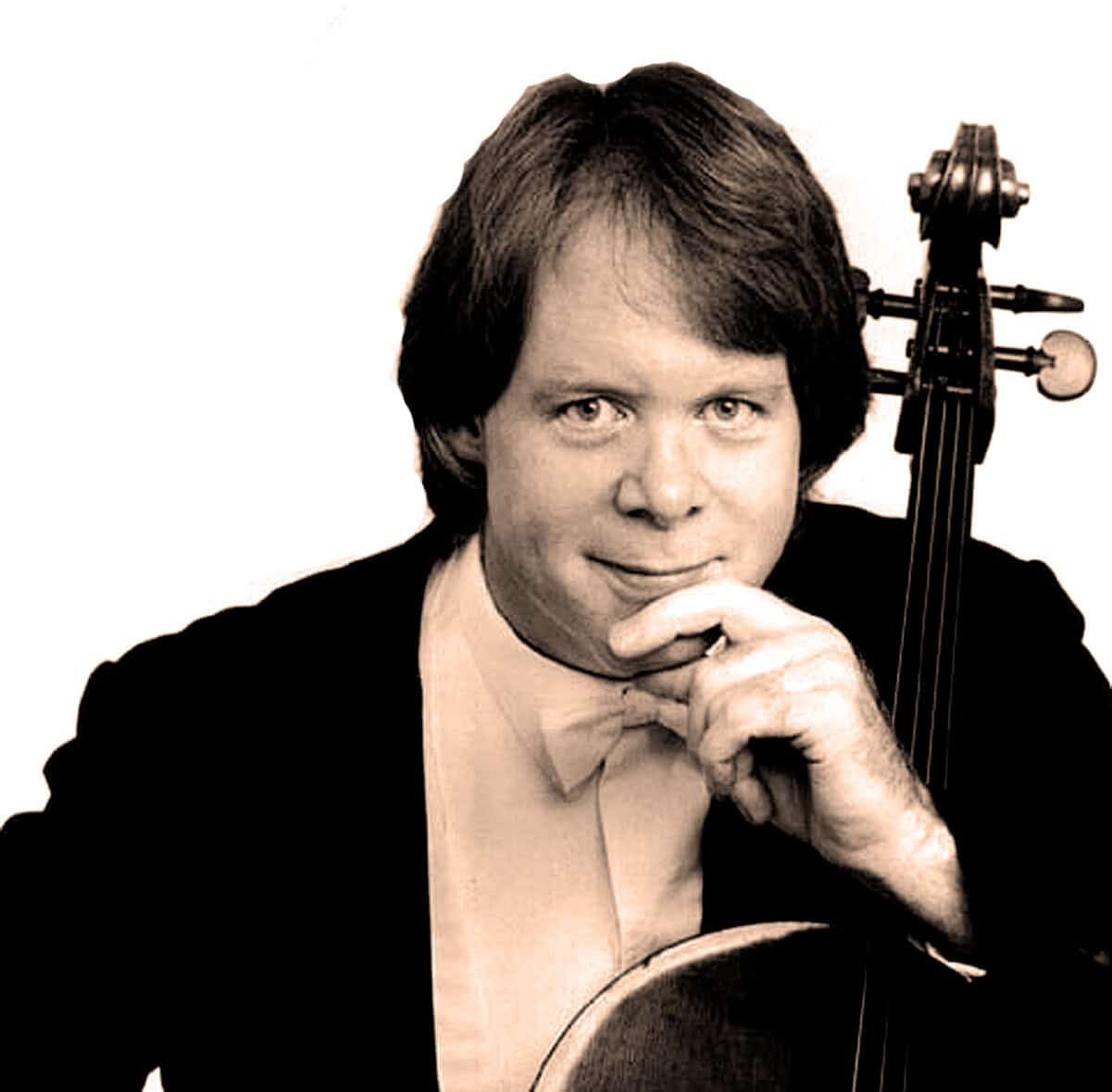 Handsome male musician with dark hair, in formal attire, holding a guitar and a cello, representing music, news, history, and sound archive content.