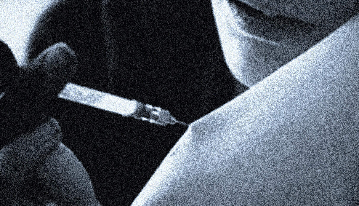 An individual preparing an injection with a syringe, symbolizing health, medical history, or medical news, relevant to news archives and historical records of medicine and healthcare practices.