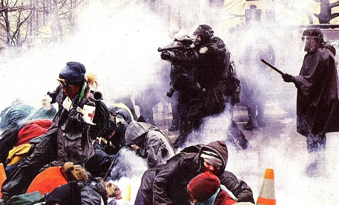 Police officers and protesters in a chaotic scene with smoke and debris, civil unrest during a demonstration, law enforcement and activists clashing, news coverage of protest conflicts, historical moments of civil disobedience and social movements.