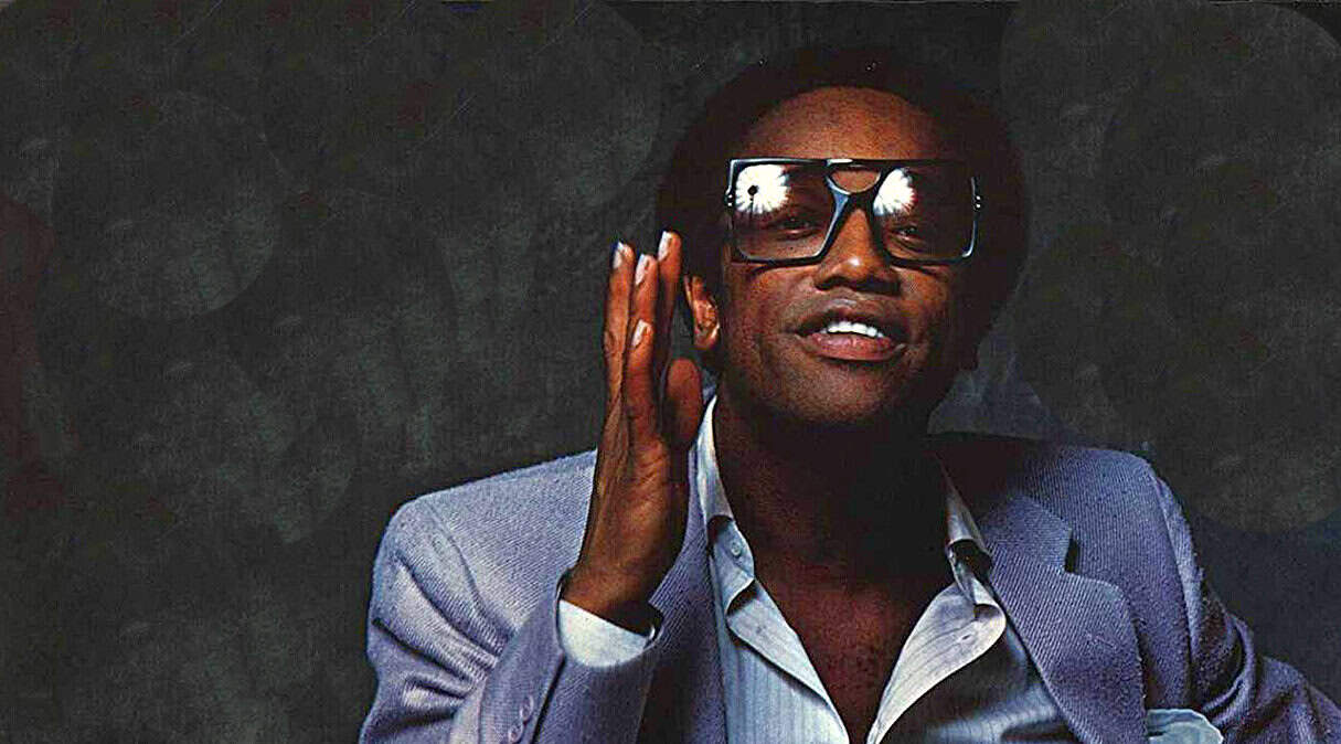 Vintage jazz musician wearing large sunglasses and a suit, captured in a classic artistic photo for music history archives.