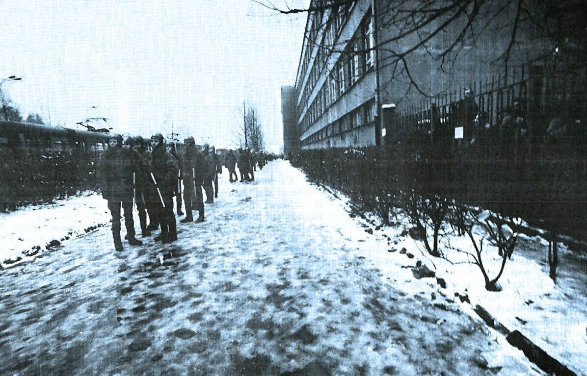 Frozen city sidewalk with pedestrians during winter in black and white, historical urban scene, reflecting cold weather, snow-covered ground, retro urban environment, archival news and music history.