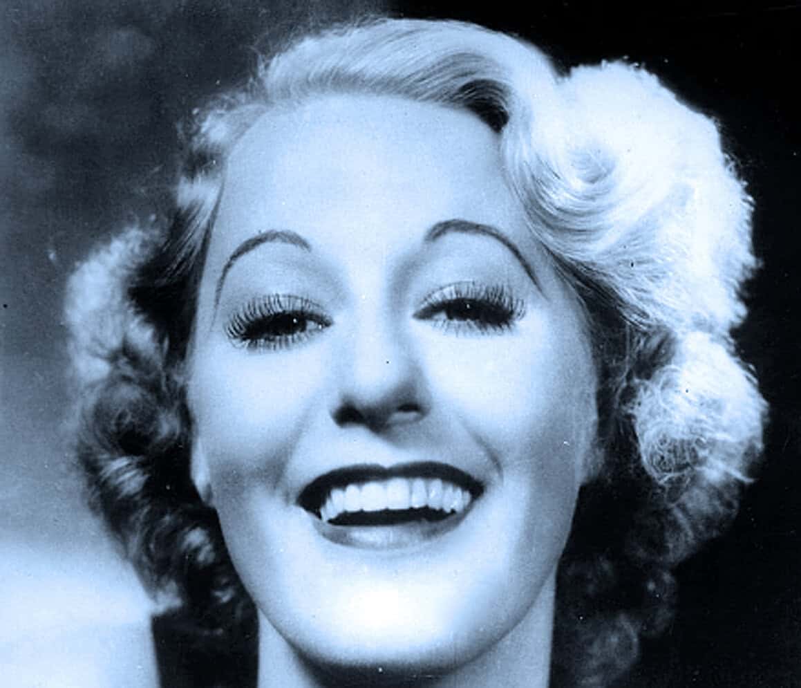 Vintage black and white photograph of a woman smiling with styled hair, reflecting classic Hollywood glamour and music history, perfect for archival and nostalgic sound recordings.