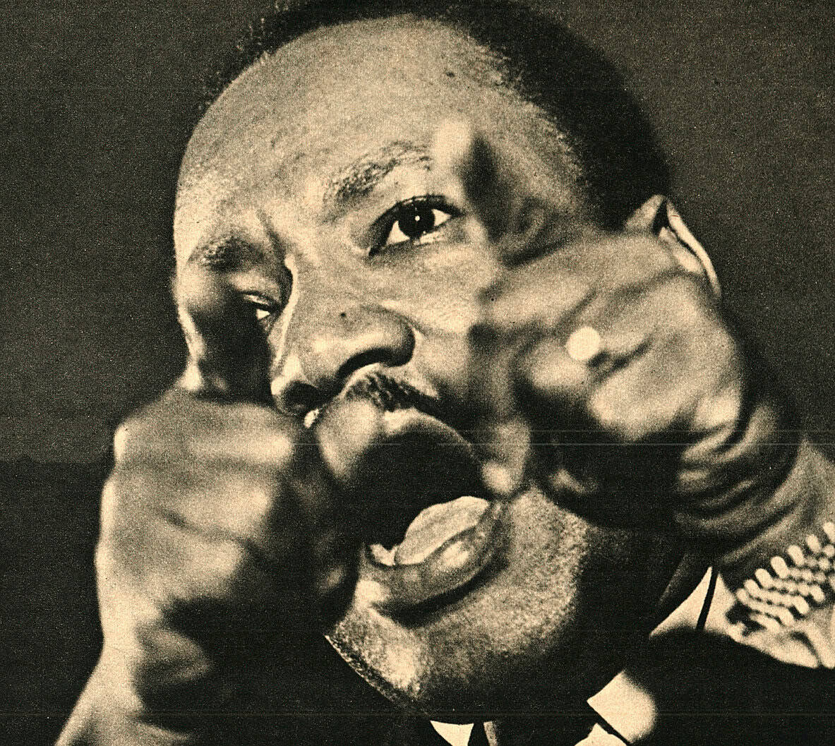 Black and white close-up of a jazz musician passionately singing into a microphone, capturing a soulful moment with expressive facial features.