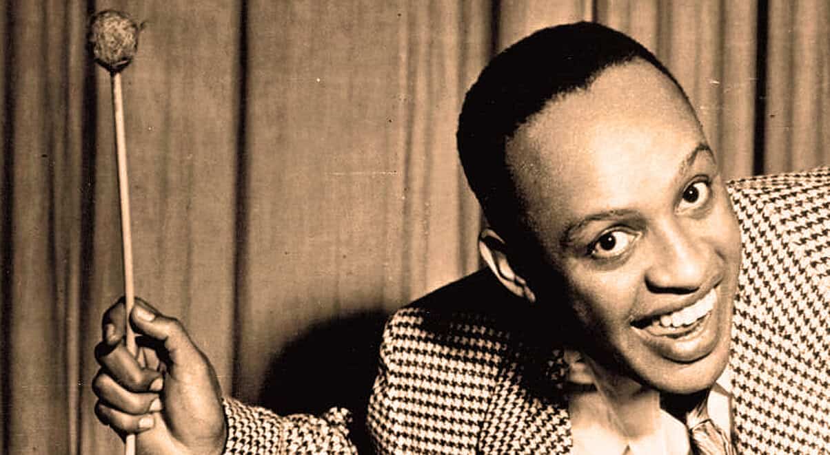 Vintage jazz musician holding a baton, black and white photo, iconic image from music history archives.