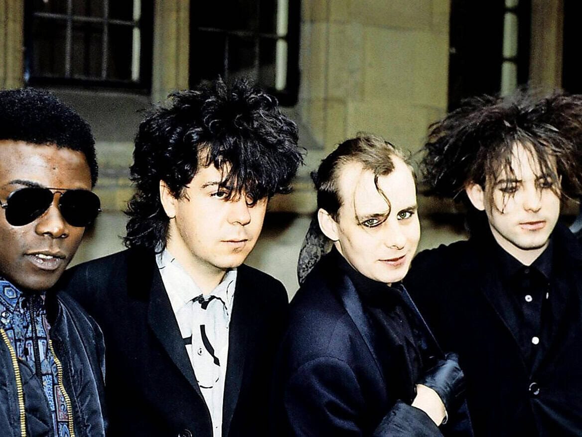 Colorful 1980s New Wave band members posing for a photo, showcasing edgy fashion, bold hairstyles, and vibrant personality in a music and pop culture context.