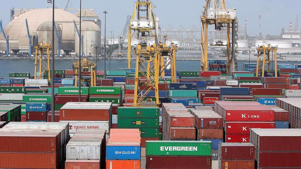 U.S. container port with colorful shipping containers and cranes, illustrating maritime trade and global logistics for news, history, and music archives.