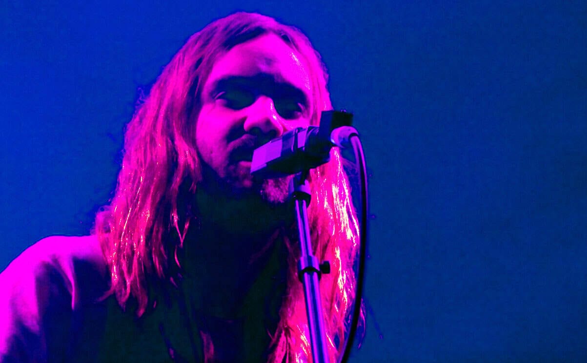 Vocalist performing live on stage with colorful lighting, capturing the essence of music history, news, and cultural events for Past Daily sound archive.