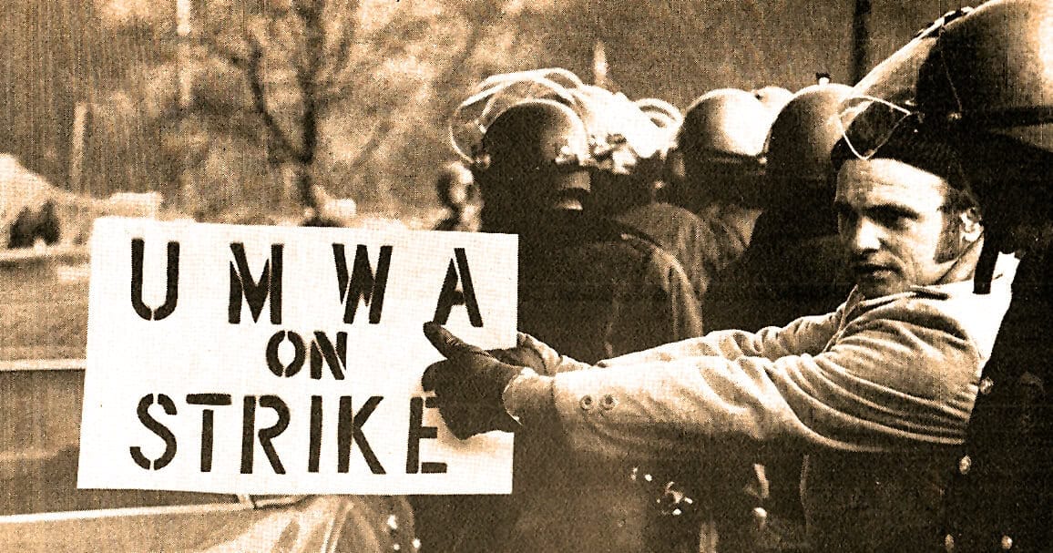 UMWA on strike protest during labor movement, historic black and white photo of coal miners holding a union sign, representing workers’ rights, labor history, and union activism.
