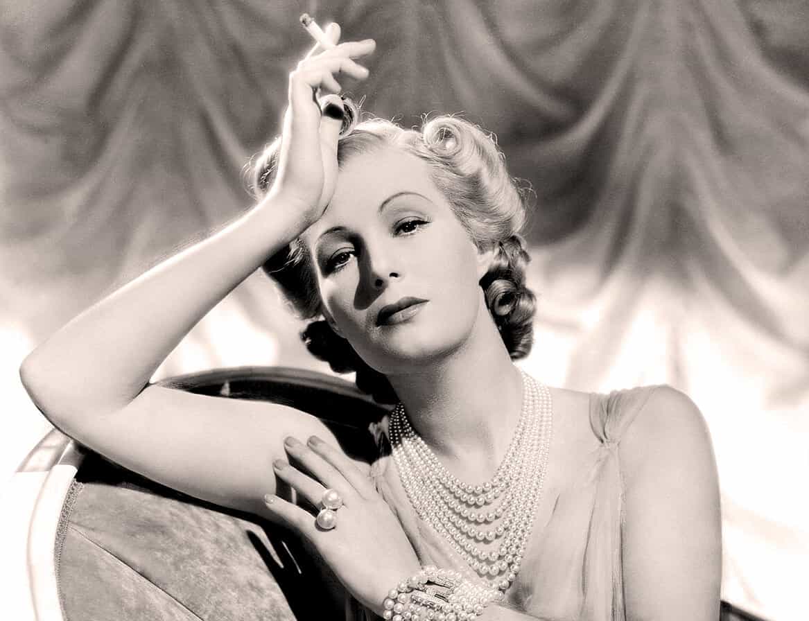 Vintage Hollywood actress elegant portrait, black and white photo showcasing glamorous jewelry, classic hairstyle, and sophisticated pose. Perfect for vintage music, film history, and entertainment SEO keywords.