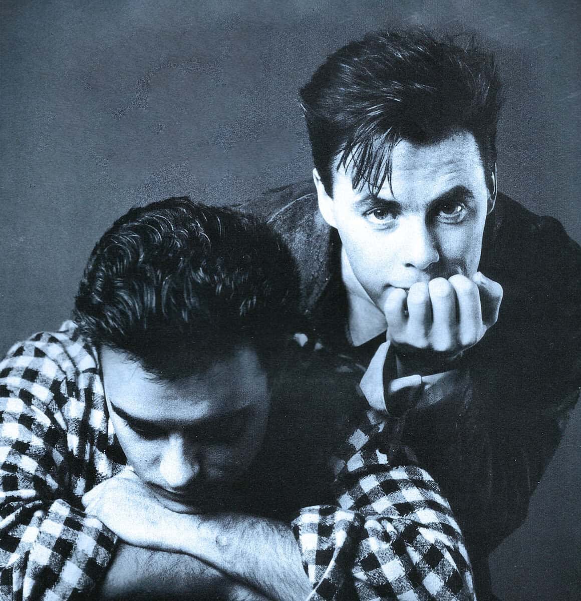 Shining bright yuppie hair, classic black and white photograph of two men, one with styled hair and intense gaze, reflecting 1950s fashion and culture.