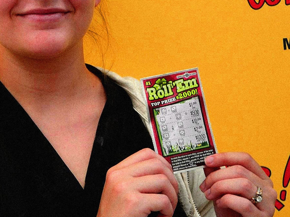 $1 lottery scratch card with woman holding it for lottery news and gambling images, close-up of hand and scratcher, colorful scratch-off ticket for news, history, and music archive on Past Daily website, entertainment.