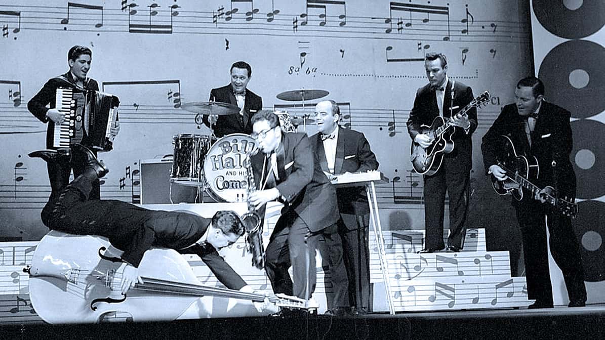 Vintage jazz band performing live on stage with musical instruments, set against a backdrop of musical notes, highlighting historical music archives and classic entertainment.