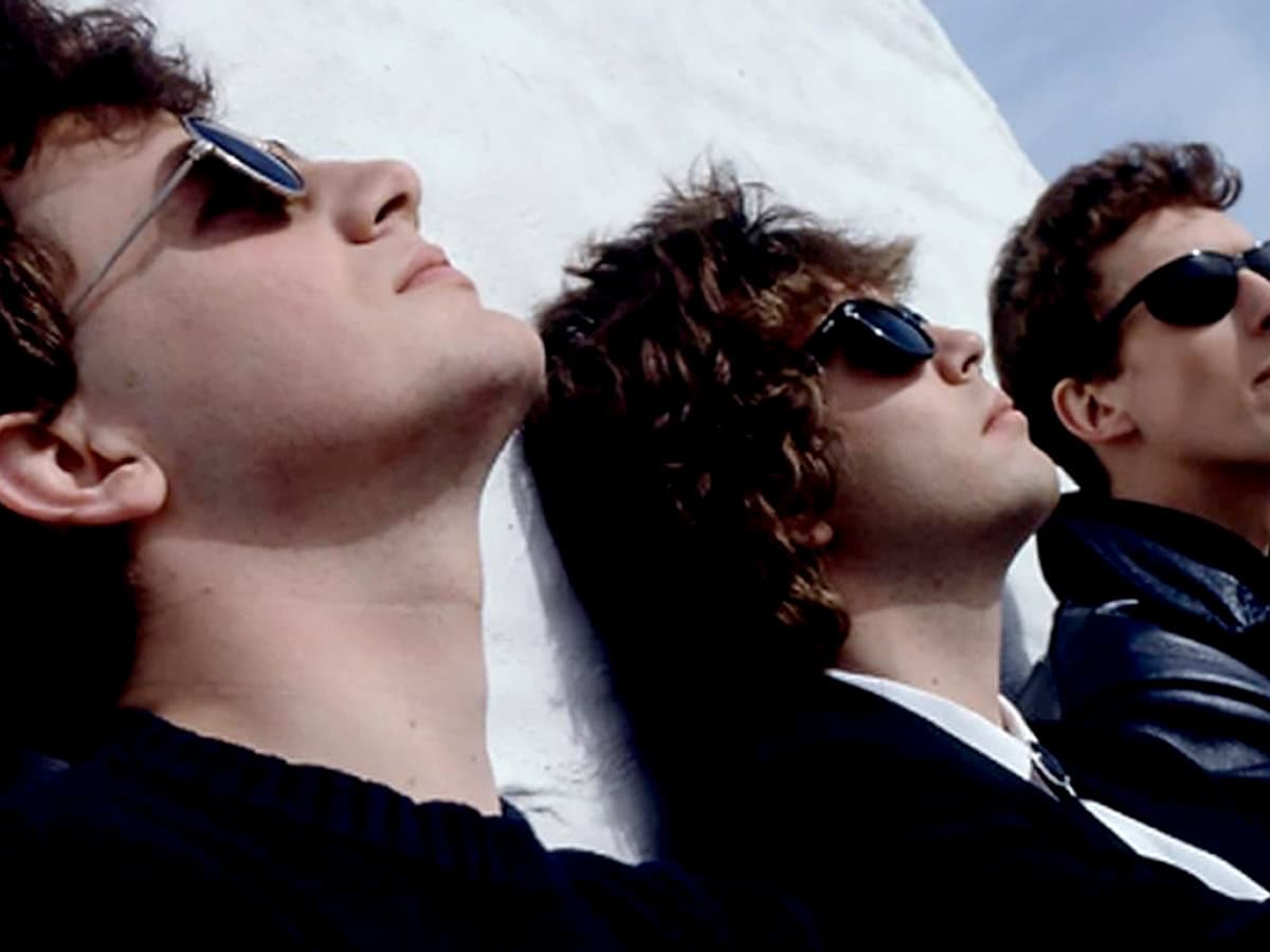 Sexy young men wearing sunglasses lying on white surface, music and pop culture, stylish casual fashion, relaxed vibe, summer style, entertainment and lifestyle, band members or friends enjoying sunny day.