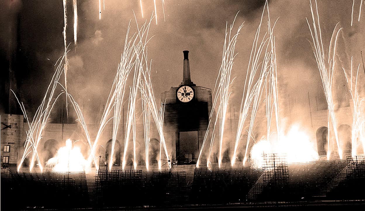 Bright fireworks and sparks illuminate a historic clock tower during a celebration or event at night, creating a dramatic and festive atmosphere.