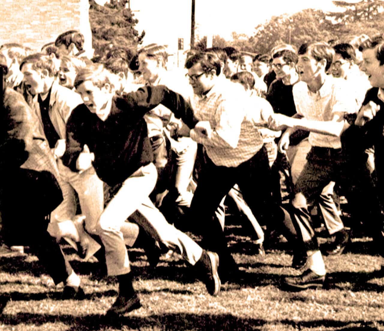 A sepia-toned image of children engaging in a tug-of-war game outdoors, showcasing a nostalgic moment of childhood play and school activities from the past.