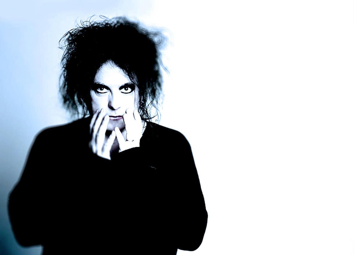 Eclectic person with wild black hair, intense gaze, and artistic style, representing a music or radio archive connection, symbolizing historical news, music, and cultural preservation from Past Daily.