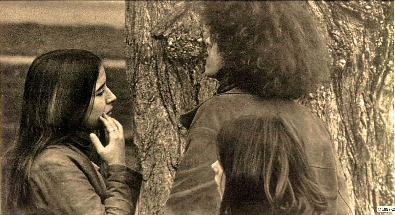 Eye-catching photograph of two women engaging in a thoughtful conversation outdoors, emphasizing themes of social interaction and community, perfect for exploring past news, history, and music archives.
