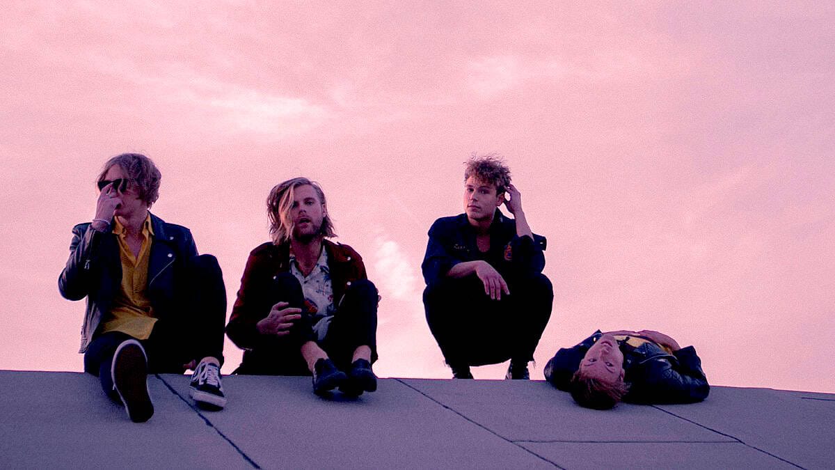 Vintage rock band sitting on rooftop during sunset, capturing music, history, and cultural moments, representing a sound archive of news, history, and music from Past Daily.
