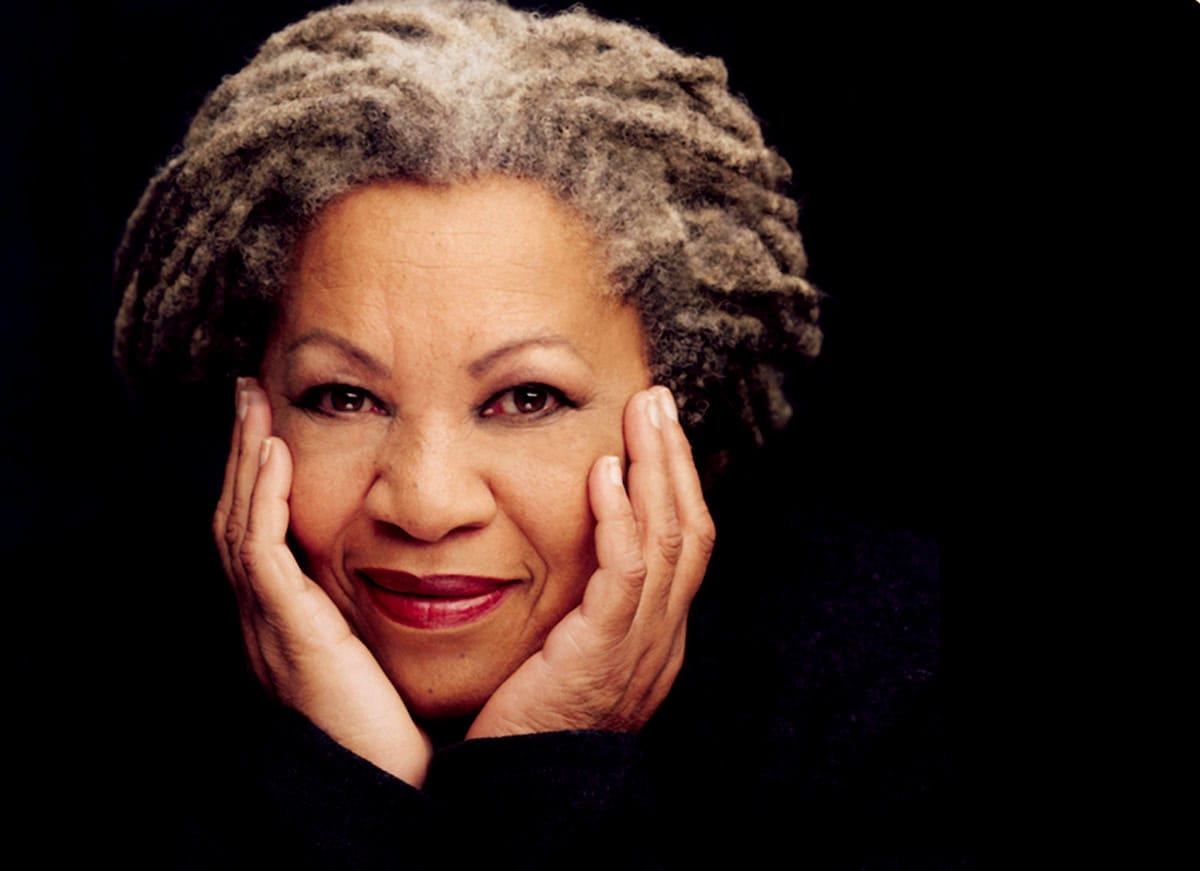 Vivid portrait of an elderly African American woman with gray dreadlocks, smiling softly and holding her face with both hands, showcasing timeless beauty and wisdom.