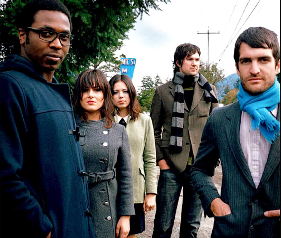 A vibrant group of young adults standing outdoors, showcasing modern fashion and urban style, capturing a moment of youth culture and music scene relevance for SEO.