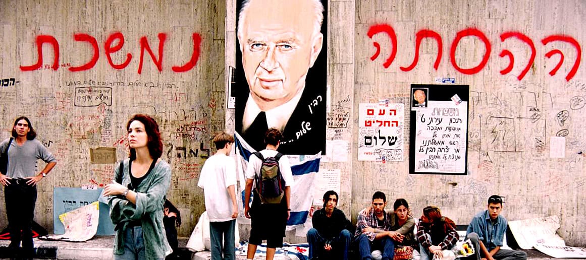 Palestinian graffiti and a portrait of Yitzhak Rabin on a graffiti-covered wall in Jerusalem, illustrating the historical and cultural significance related to Middle Eastern politics and history.