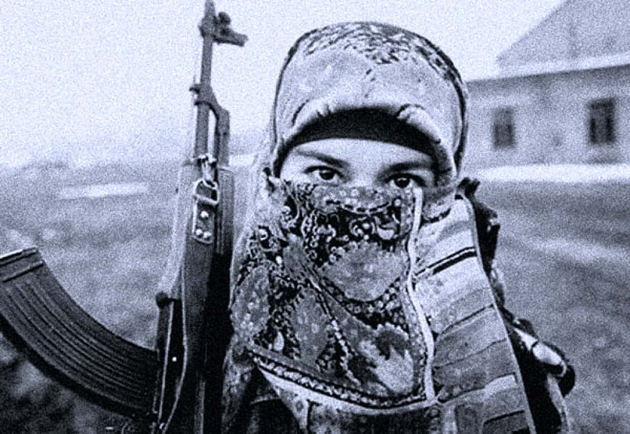 Armed female soldier with camouflage mask and rifle in a conflict zone, historic war photograph, military personnel, peace and conflict, news archive, historical documentary image.