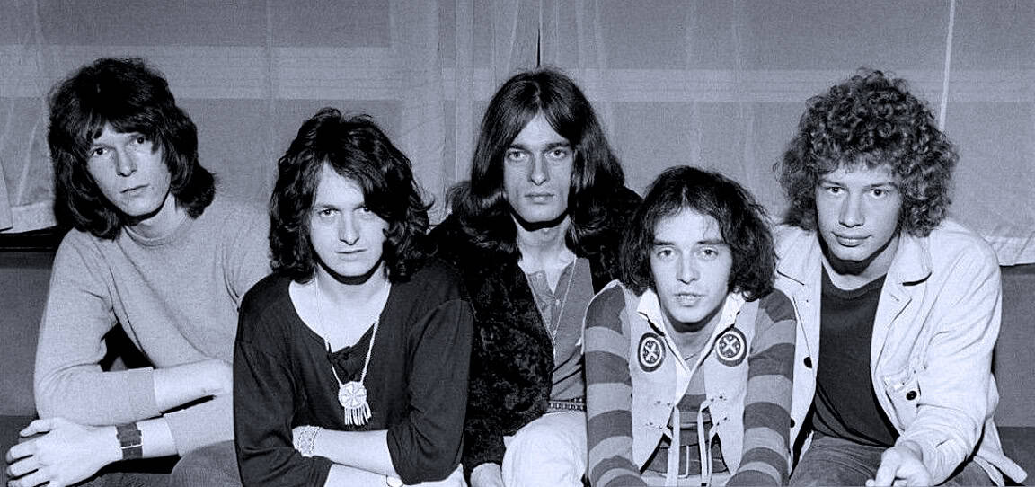 Vintage black and white photograph of a classic 1970s rock band, featuring five members with curly and straight hairstyles, showcasing iconic music history and legendary musicians.