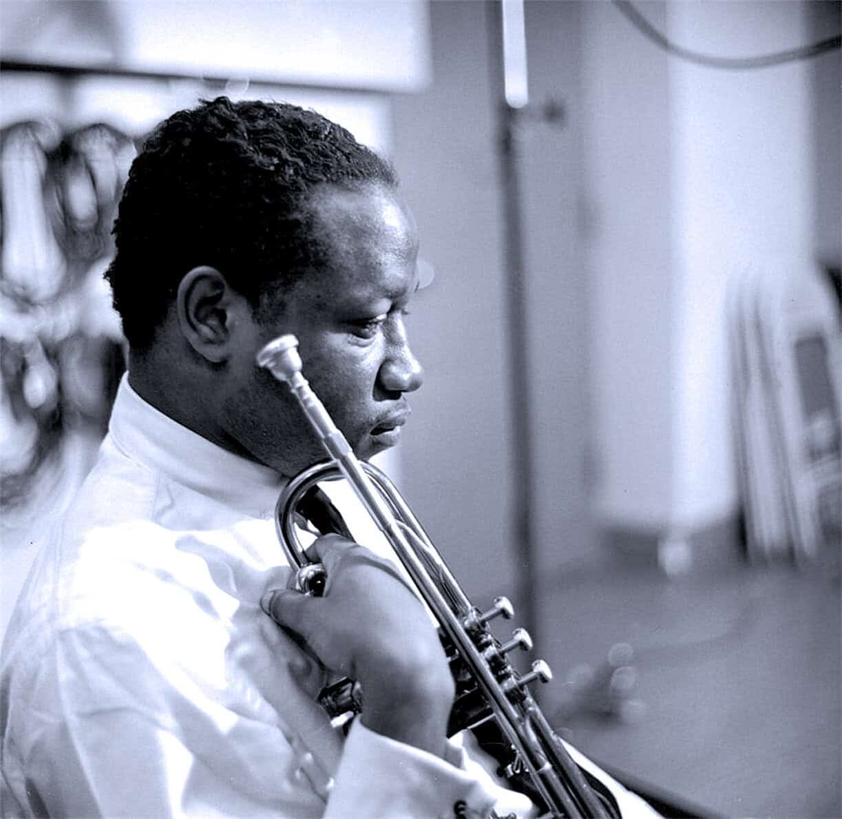 A jazz musician playing the trumpet in a recording studio, capturing a moment of musical history and skill, emphasizing the rich cultural heritage of jazz music and its archival significance.