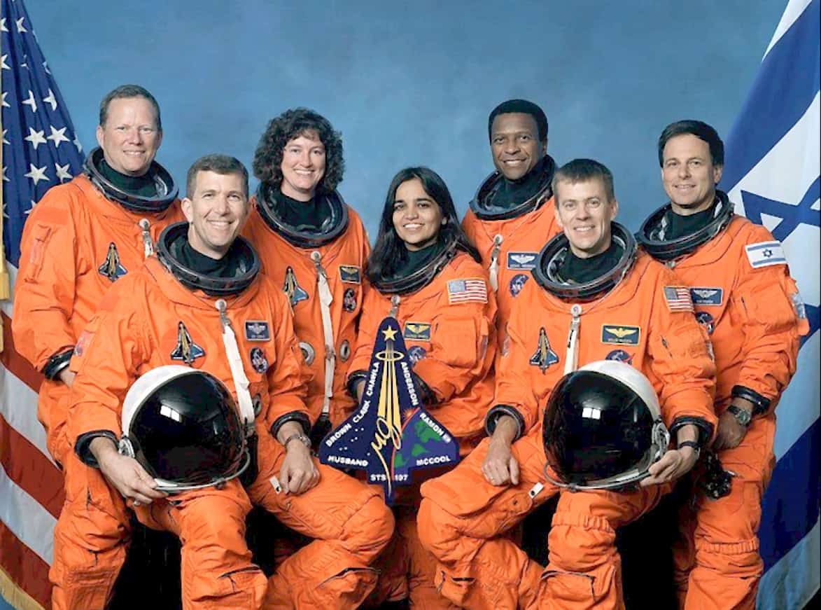NASA astronauts in orange spacesuits posing with American flags, celebrating a space mission or event, showcasing space exploration, history, and groundbreaking achievements in space travel.
