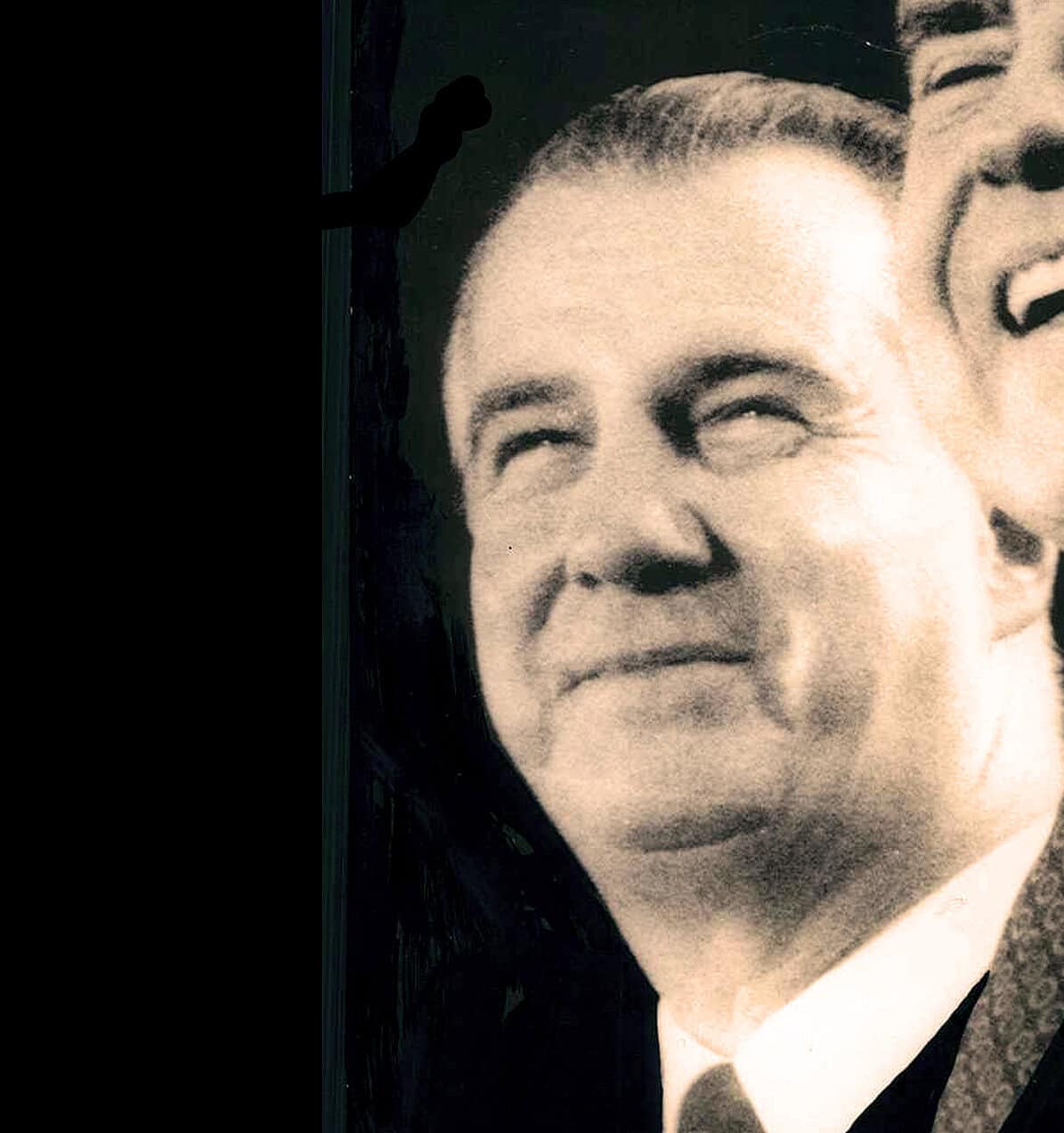 Vintage black and white photograph of a smiling woman with a distinctive hairdo, reflecting historical news and music archives from Past Daily.