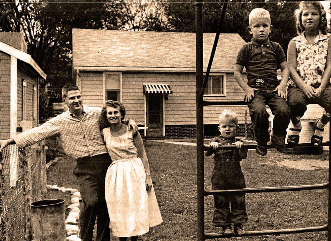 Family outdoor portrait of parents and children in backyard, vintage sepia photo, nostalgic image of childhood and family life.